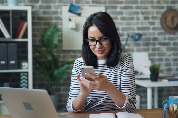 a woman sitting at a table looking at her cell phone